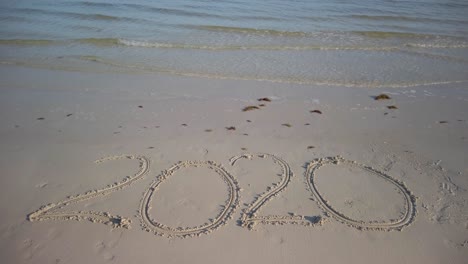 twenty twenty inscription in the sand on a beach