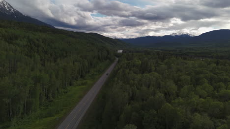 car driving the scenic alaska highway through yukon’s wilderness