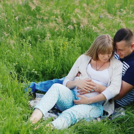 man and pregnant woman in a meadow