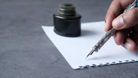 persona que escribe con una pluma pluma