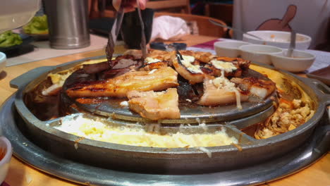 korean hot plate barbeque with various cuts of meat and melting cheese