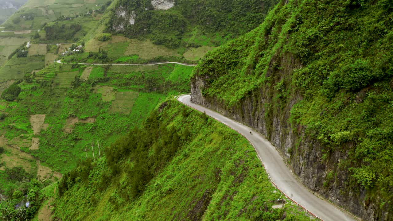 구불구불한 도로를 따라 여행하는 오토바이가 베트남 북부의 마피렝 패스에서 산쪽으로 잘려나갔다.