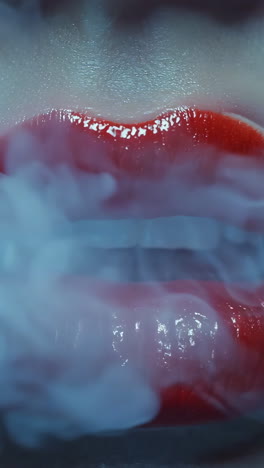 a woman's lips are painted red and she is surrounded by smoke. concept of mystery and intrigue, as the woman's lips seem to be the focal point of the scene. the smoke adds an element of danger