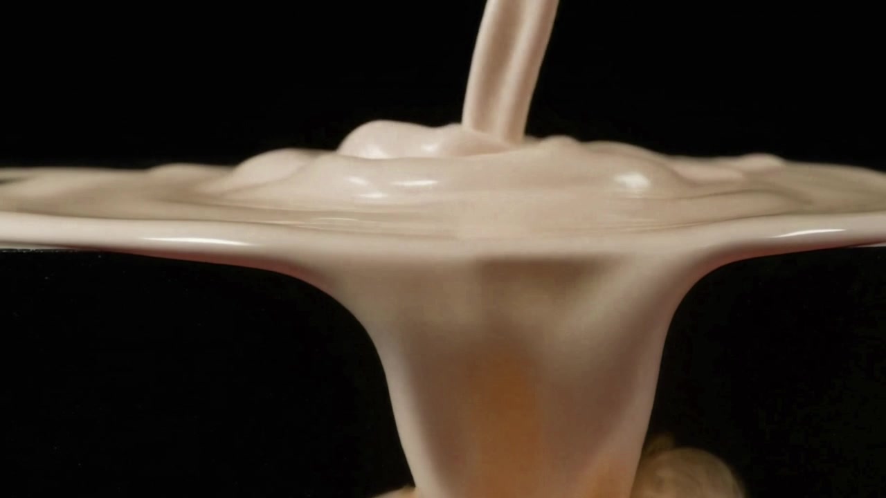 Creamy Liquid Pouring Over Edge in Slow Motion