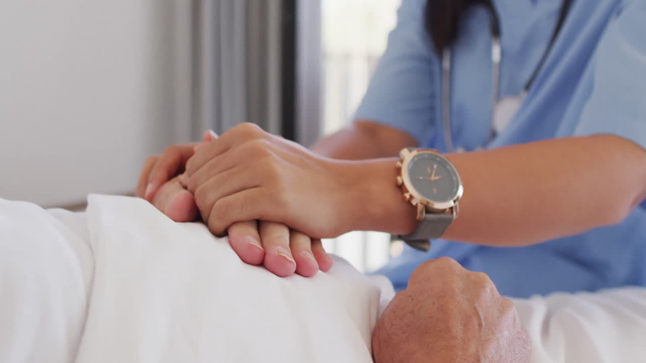 animación de las manos de una doctora biracial que cuida a un anciano caucásico