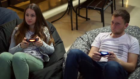 Young-couple-playing-video-game-at-home.-Shooting-and-controlling-using-the-game-controller.-Wireless-game-controller.-Slow-Motion