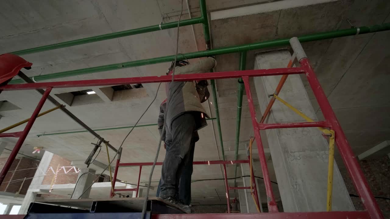 los trabajadores profesionales instalan tuberías de alcantarillado o de suministro de agua en una fábrica moderna. construcción de una fábrica, hangar