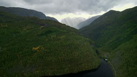Drone-flies-over-a-lake-of-Norway-with-the-view-of-the-mountains-with-sunbeams