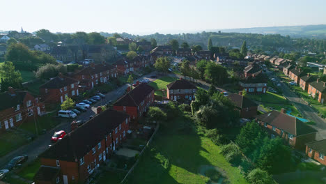 Aerial-video-unveils-Dewsbury-Moore-Council-estate,-a-UK-urban-area,-with-red-brick-housing-and-Yorkshire's-industrial-landscape-on-a-sunny-summer-morning