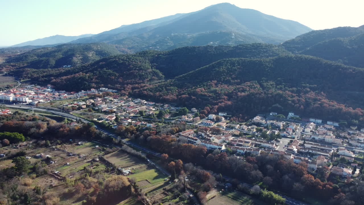 Aerial View of a Town Nestled in a Valley with Mountains in the Background
