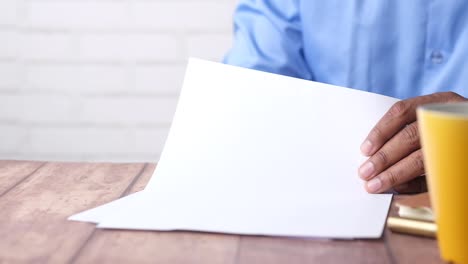 persona que lee un documento en el escritorio