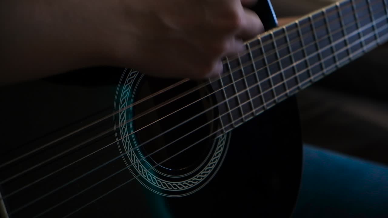 persona que toca una guitarra acústica negra