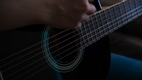 person playing a black acoustic guitar