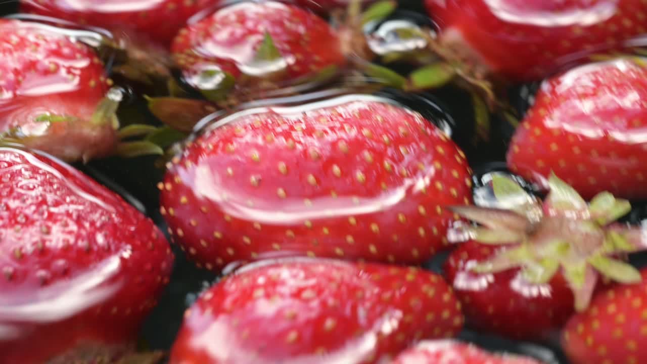 fresa extrema de cerca de alimentos de frutas saludables flotando en agua clara después de recoger