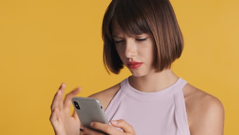 una mujer enojada recibe un mensaje en el teléfono.
