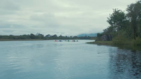 Grupo-De-Kayakistas-Remando-En-El-Río,-Amplia-Toma-De-Seguimiento