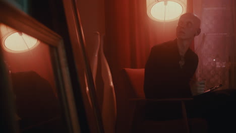 person sitting in red light interior