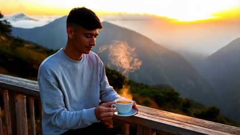 man enjoying a hot drink at sunrise/sunset in the mountains