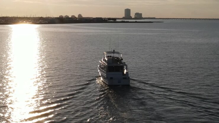 White Luxury Yacht Sailing Towards The Lakeview Area During Golden Hour In New Orleans, USA. aerial