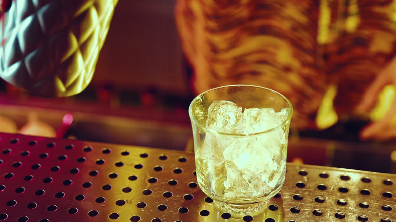 el camarero vertiendo una bebida.