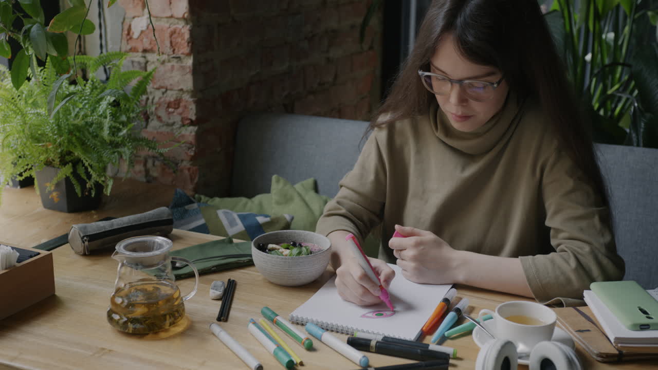 Woman Drawing in a Cafe