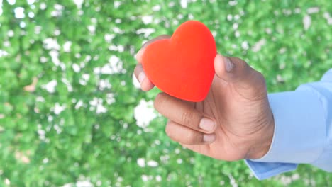 mano sosteniendo un corazón rojo