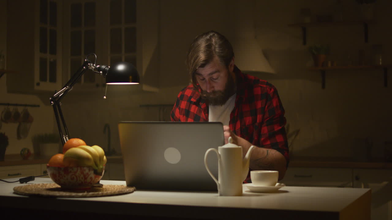 hombre estresado trabajando hasta tarde en casa
