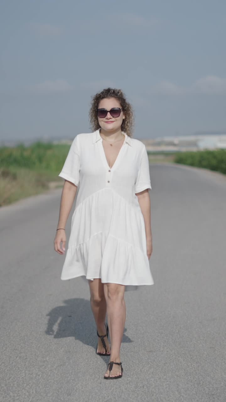 Woman in white dress walking on road