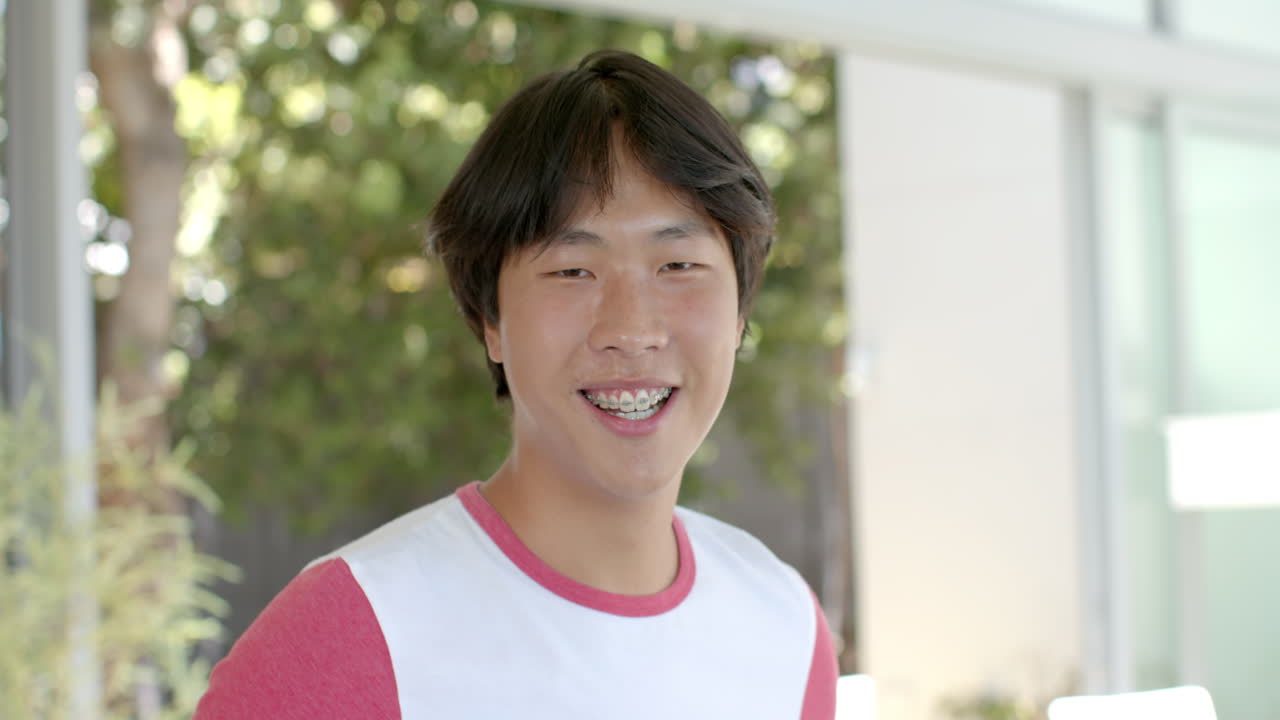 십대 아시아 소년은 복사 공간과 함께 야외에서 밝게 미소