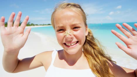 portrait of caucasian girl on beach with starfish