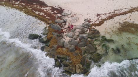 turquoise waves crashing against rocky outcrop featuring tourists relaxing on sandy beach, capturing idyllic seaside scenery in playa del carmen, mexico's stunning riviera maya coastline