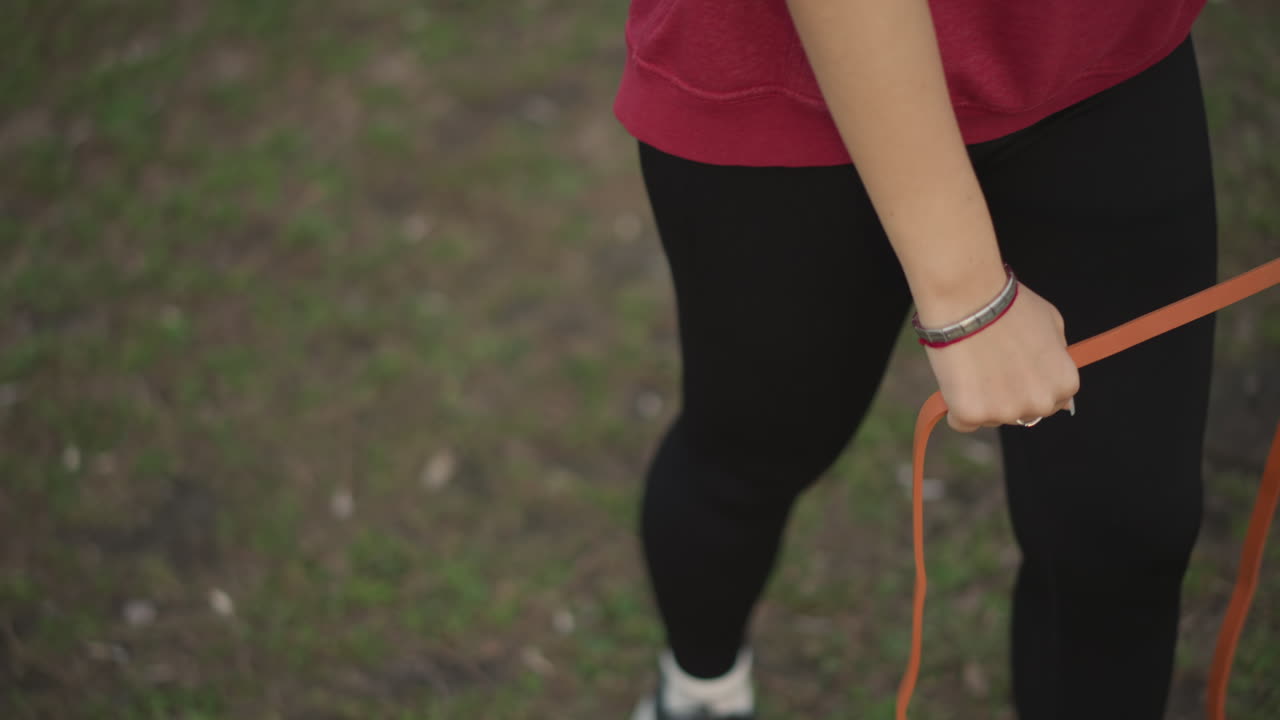 Consistent Stroll Exercise, Slow And Controlled Walking Exercise With Resistance In Park Setting, Steady Outdoor Walking Involving Resistance Band For Improved Posture And Stability Exercises
