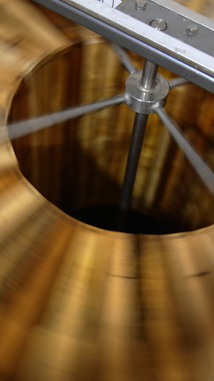 Fresh organic honey being extracted from wooden frames. Centrifuge machine rotating quickly for harvesting honey at apiary. Vertical video