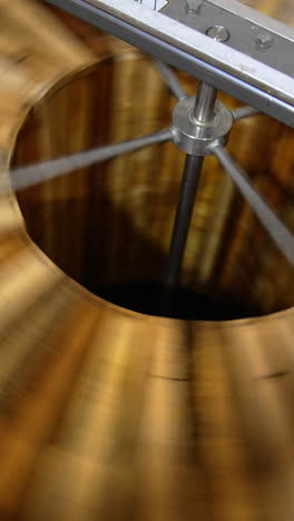fresh organic honey being extracted from wooden frames. centrifuge machine rotating quickly for harvesting honey at apiary. vertical video