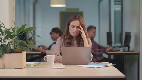 business woman working on computer at coworking. upset entrepreneur reading news