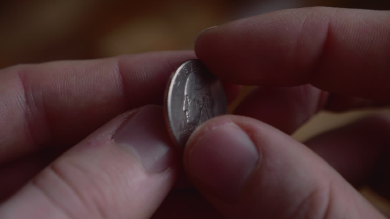 dedos lanzando una moneda de un cuarto de dólar. de cerca