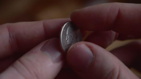 fingers flipping quarter dollar coin. close up