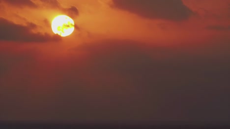 timelapse, a large sun sets in orange clouds that turn blue