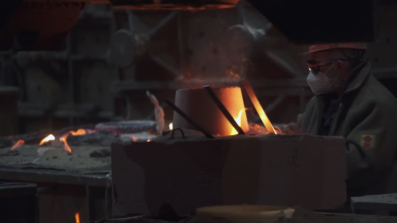 Metalworker Handling Molten Metal in a Foundry