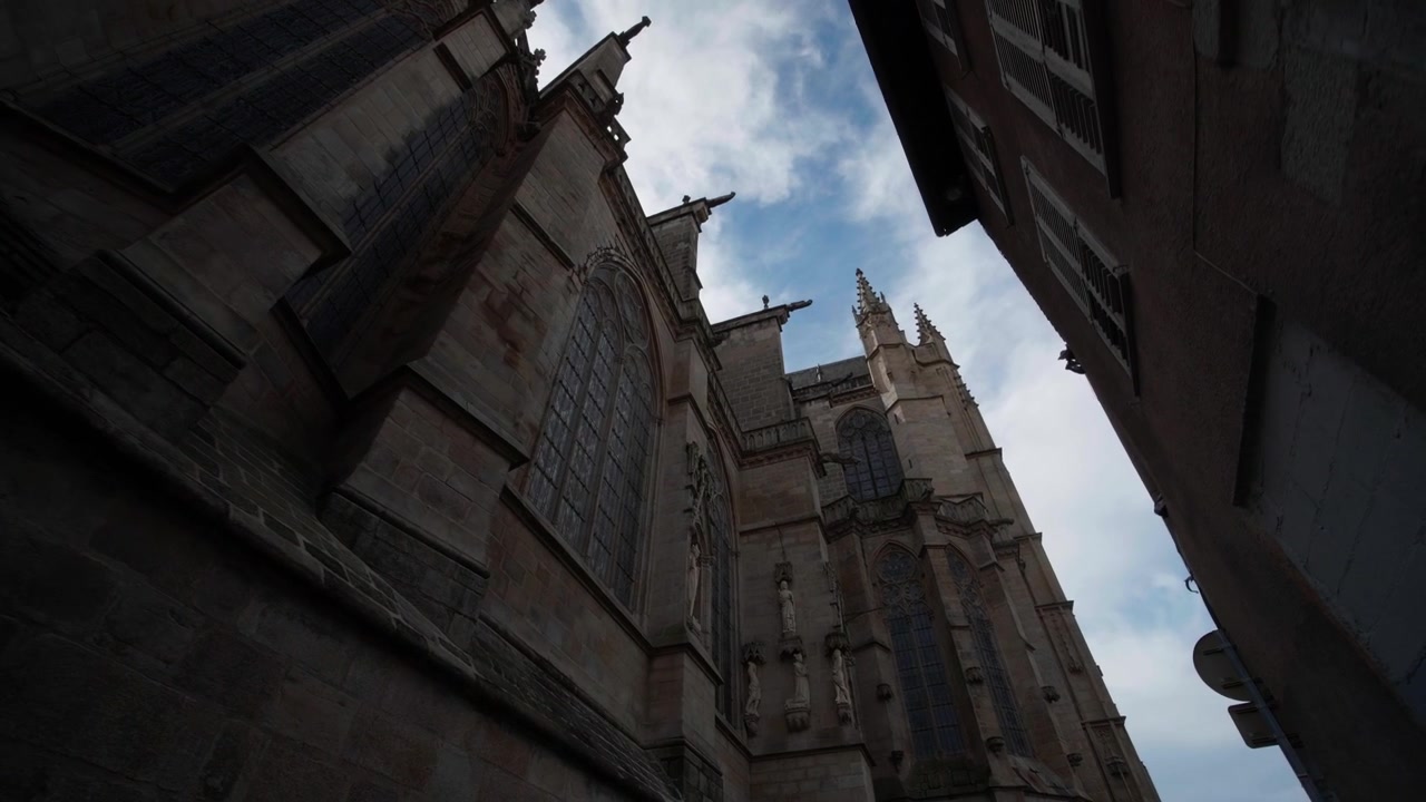 Arquitectura gótica y detalles de piedra de la Catedral de San Esteban en Limoges, destacando contra un cielo azul brillante. Vista en contrapicado desde la calle.