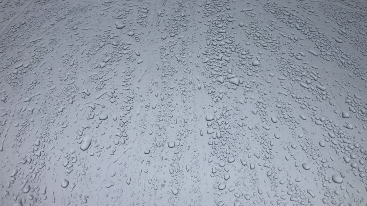 gotas de agua siguiendo hacia abajo en fondo gris. gotas de lluvia goteando hacia abajo aisladas. mejores imágenes de 4k gotas de aguas en vidrio gris corriendo hacia abajo. perfecto para la composición digital