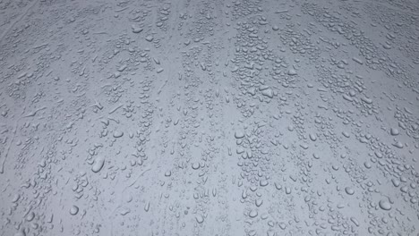 gotas de agua siguiendo hacia abajo en fondo gris. gotas de lluvia goteando hacia abajo aisladas. mejores imágenes de 4k gotas de aguas en vidrio gris corriendo hacia abajo. perfecto para la composición digital