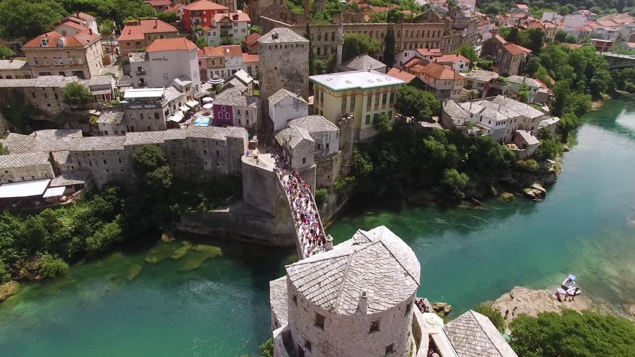 조감도는 mostar 다리와 mostar 보스니아에서 통과하는 neretva 강에 모인 군중을 보여줍니다.