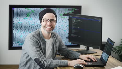 retrato de un hombre adulto en el lugar de trabajo. el programador sonríe y mira a la cámara. empleado positivo y seguro de sí mismo de la empresa