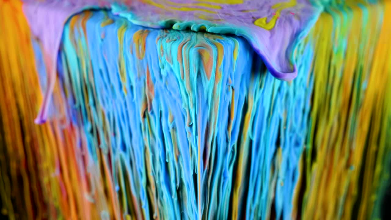 pintura de tinta multicolor fluye lentamente desde el cubo bajo el agua