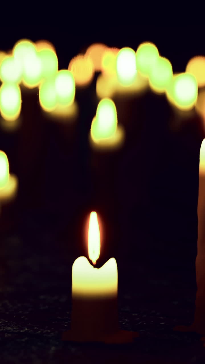 Candele accese di notte creano un bagliore caldo in un ambiente buio.