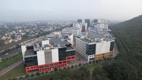 Aerial-Drone-Shot-Of-Corporate-Buildings-Near-A-Hill