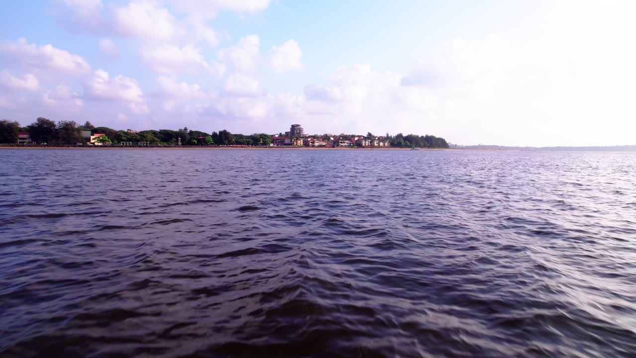 Foce del fiume nel Mar Arabico con il fiume Mandovi a Quegdevelim Beach, Panaji, Goa, India. Diurno, carrellata in avanti, angolazione dal basso, ripresa con drone, 4K