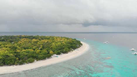 aerial footage of balicasag island in philippines. stunning view on coral reef and circle island. panglao, bohol, white beach, palm trees, boats / 4k drone video