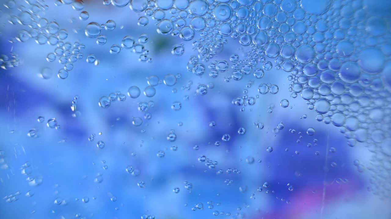 추상적인 기름은 다채로운 물에 떨어집니다.